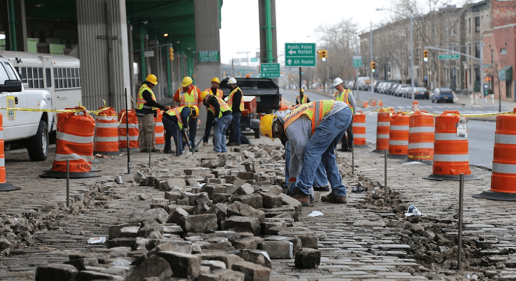 Construction on NYC Streets. Contractors opening the roadway and sidewalk.